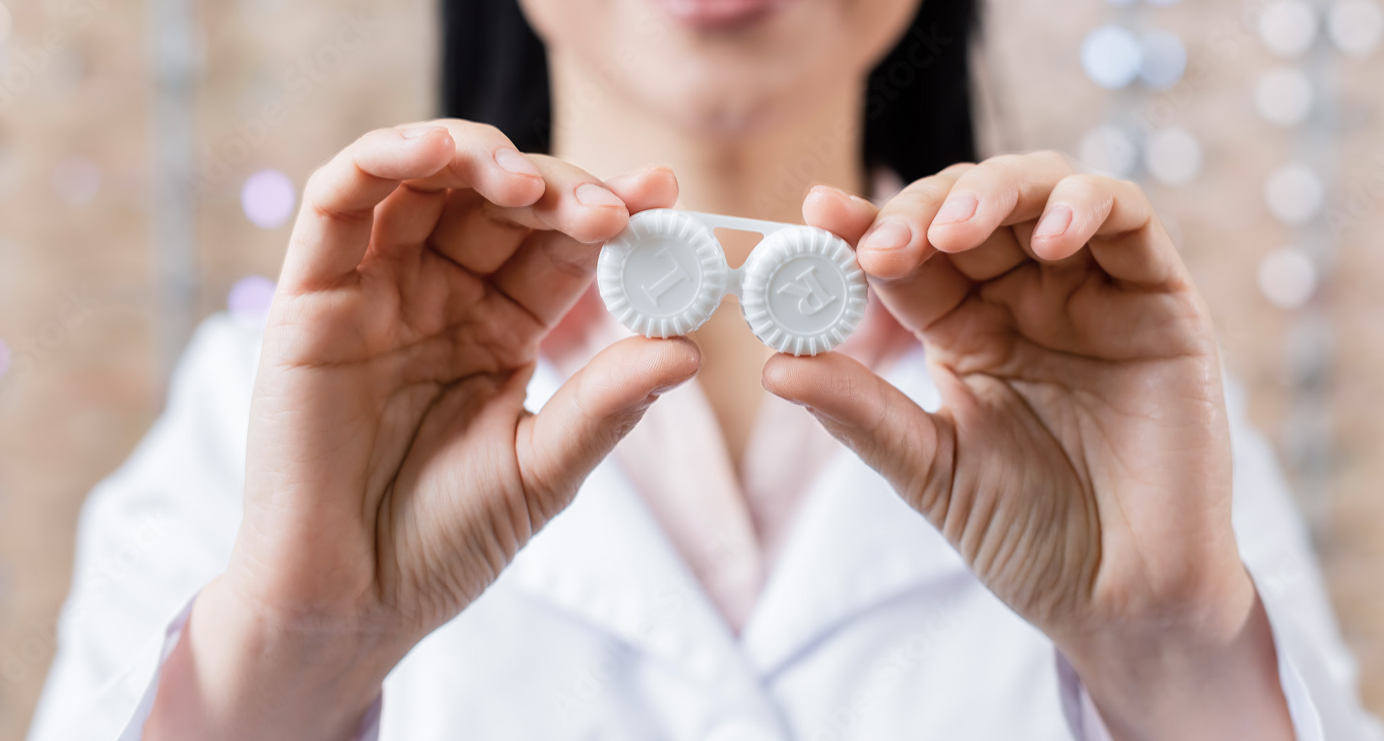 hands holding white contact lens case