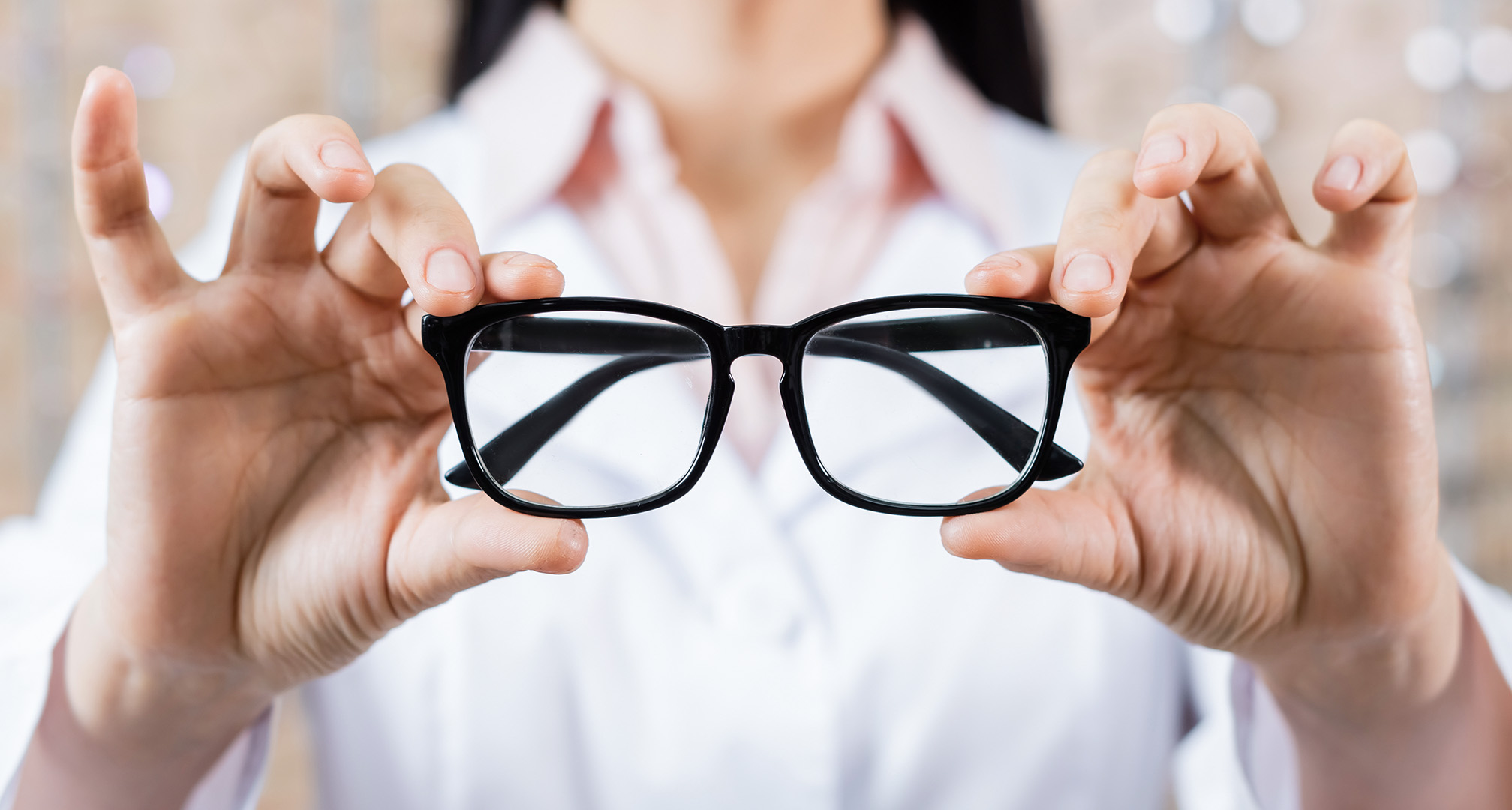 hands holding black glasses