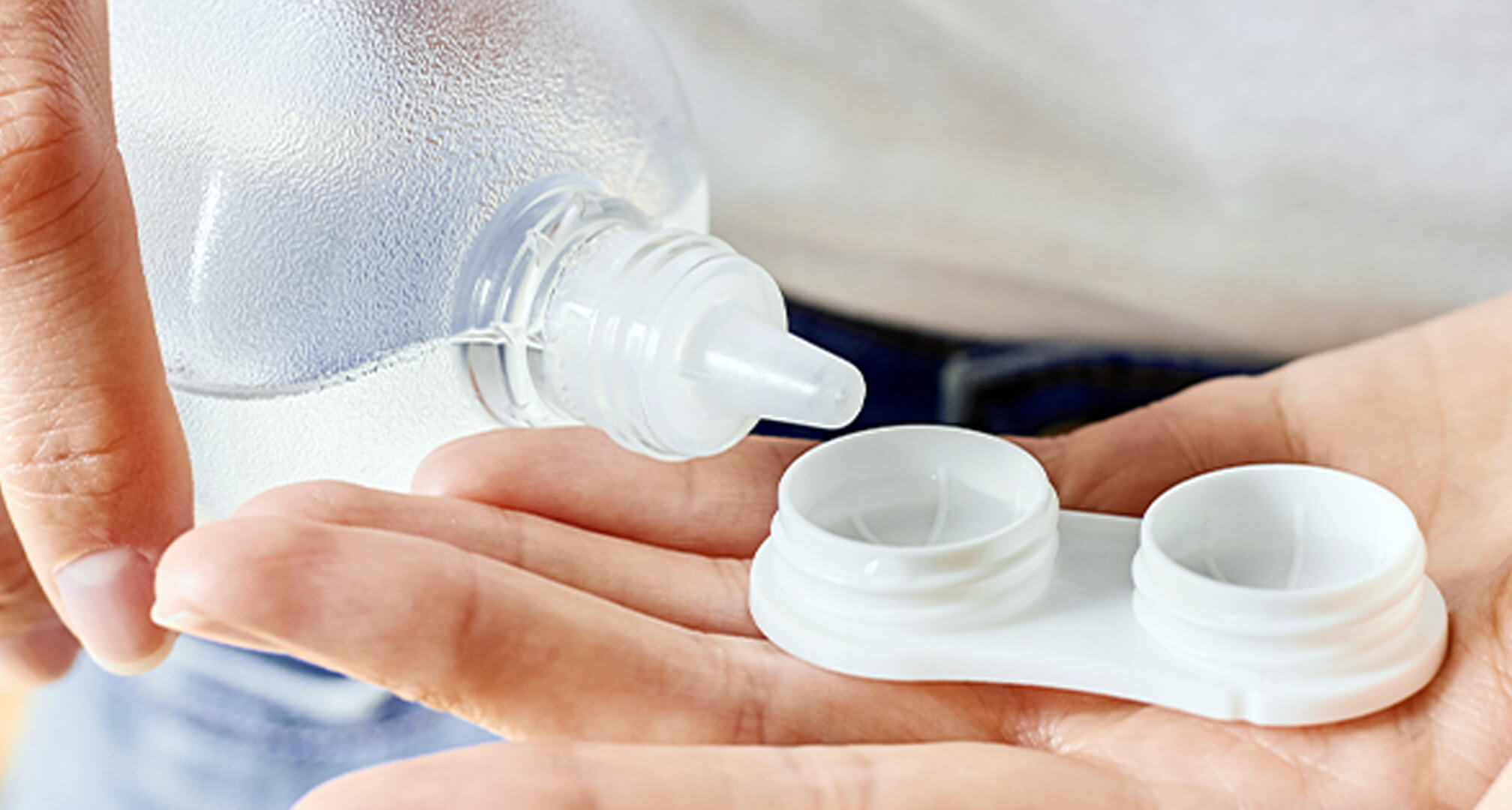 hand holding contact lens case with solution
